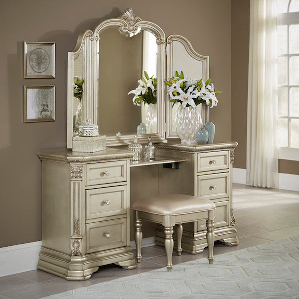 Decorative vanity with mirror and stool in a room with framed pictures on the wall.