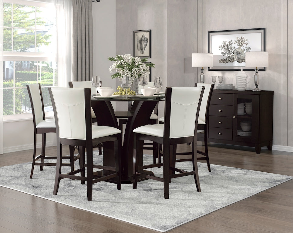 Dining room with a dark wooden table and chairs with white cushions, a gray rug, and a sideboard.