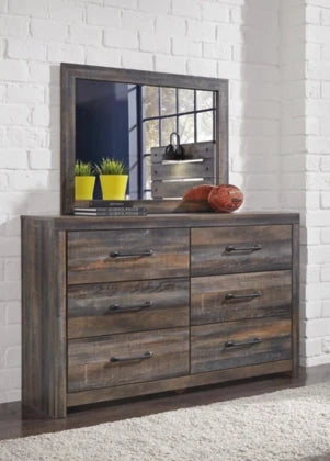 Wooden dresser with mirror against a white brick wall