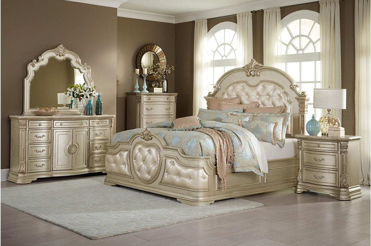 Homelegance Antoinetta 6-piece bedroom set in champagne finish, featuring a queen panel bed, dresser, mirror, and nightstand with ornate carvings and marble accents.