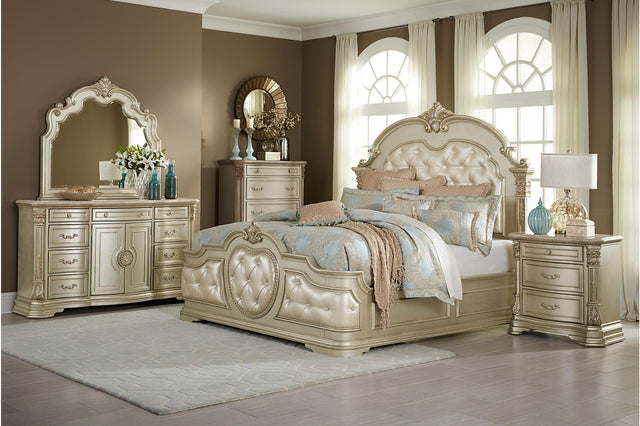 Homelegance Antoinetta 6-piece bedroom set in champagne finish, featuring a queen panel bed, dresser, mirror, and nightstand with ornate carvings and marble accents.