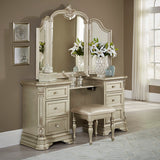 Decorative vanity with mirror and stool in a room with framed pictures on the wall.