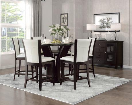 Dining room with a dark wooden table and chairs with white cushions, a gray rug, and a sideboard.