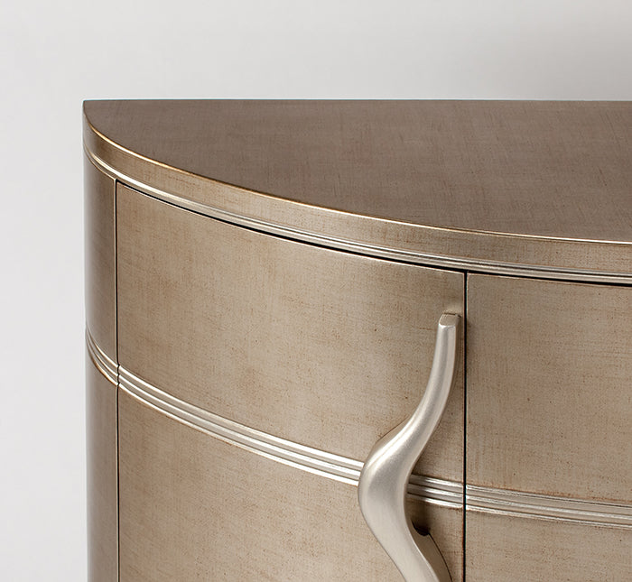 Close-up of a beige curved surface with a metallic handle on a white background