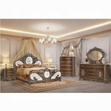 Luxurious bedroom with ornate furniture including a bed, dresser, and mirror.