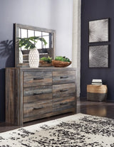 Wooden dresser with mirror in a room with dark walls and a rug.
