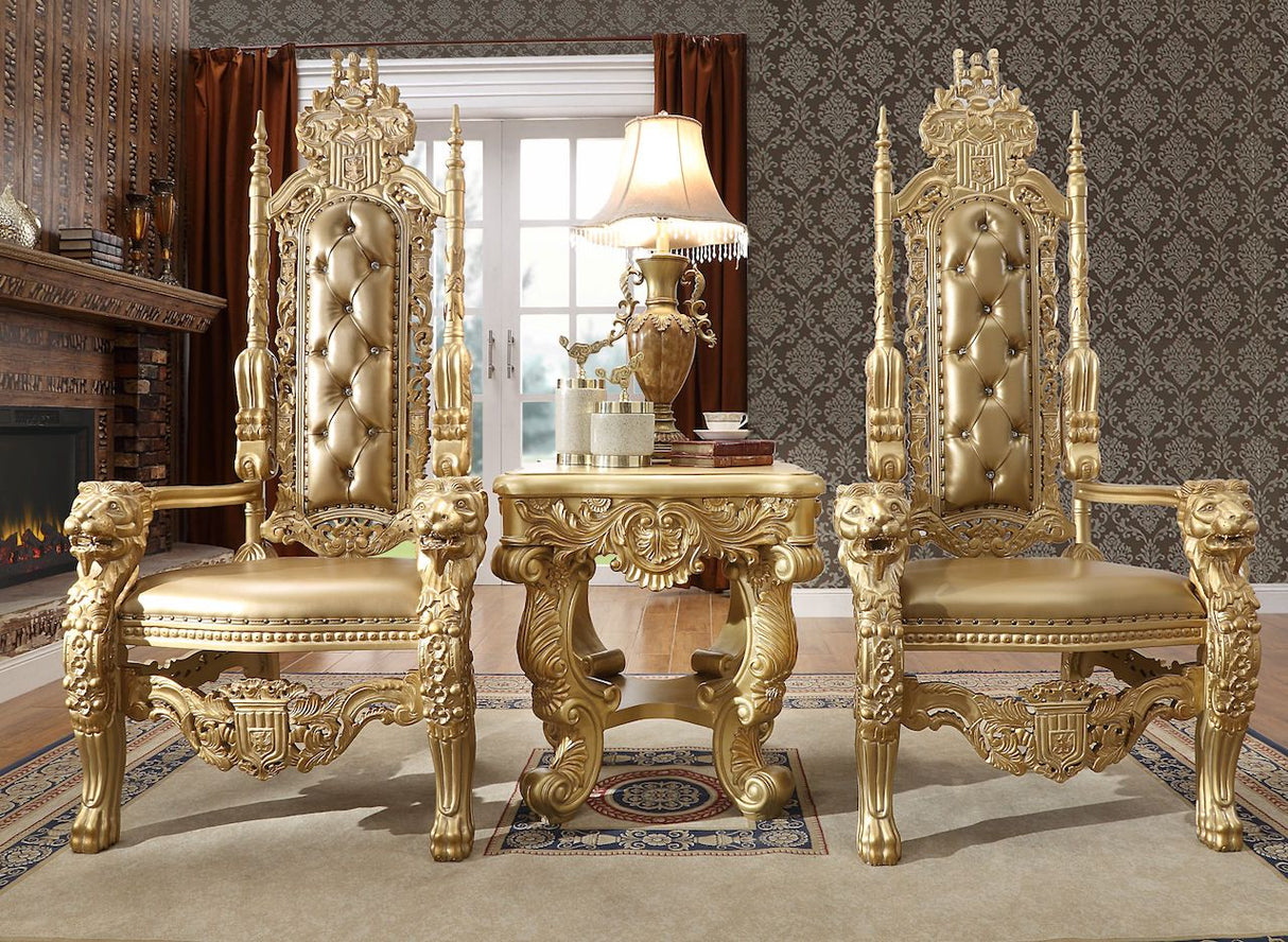 Ornate gold throne chairs in a luxurious room with a fireplace and lamp.