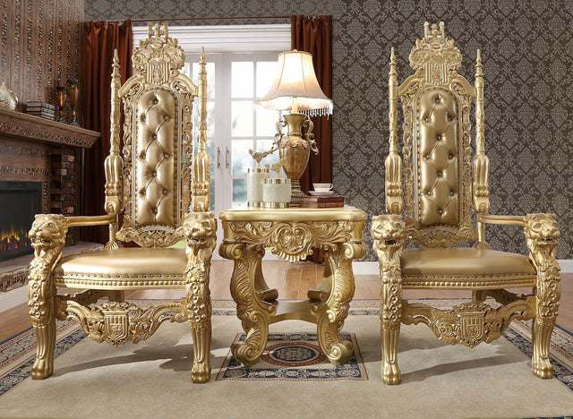 Ornate gold throne chairs in a luxurious room with a fireplace and lamp.