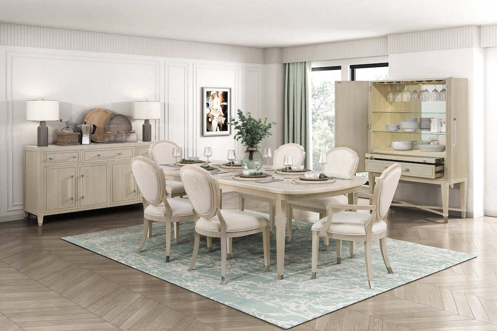 Dining room with a table and chairs on a rug, sideboard, and display cabinet.