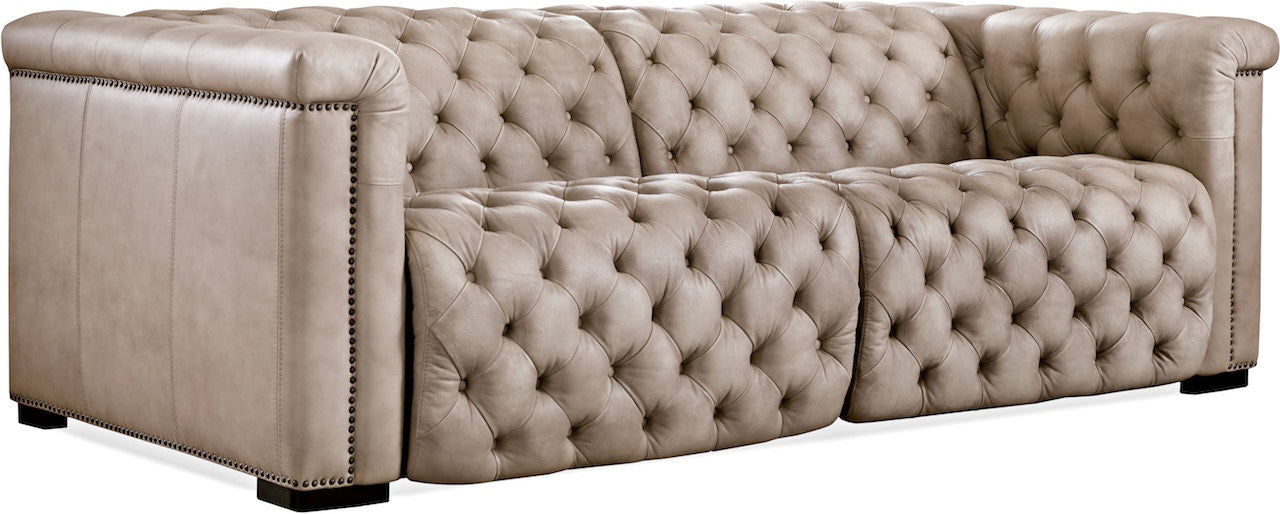 Beige tufted sofa with nailhead trim on a plain background