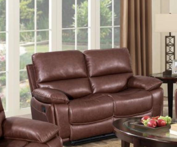 Brown leather recliner sofa in a living room setting with a table and decorative items.