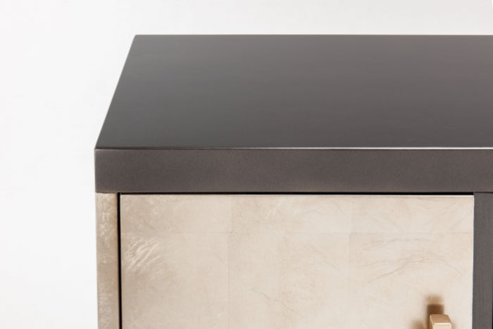 Close-up of a furniture piece with a dark top and light base. Home Elegance USA