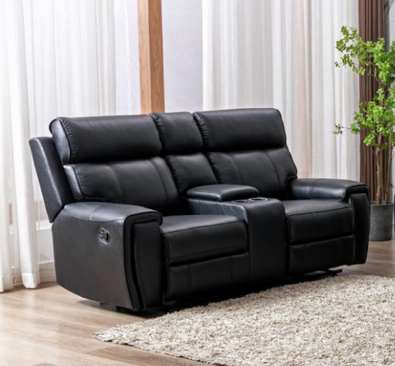 Black leather reclining sofa in a living room setting with curtains and a plant.