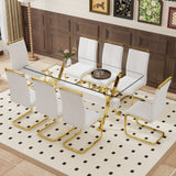 Juego de mesa y sillas. Elegante juego de comedor de vidrio templado transparente - 71'x35.4' con 8 sillas de PU blanco con patas de metal de tubo en C dorado.