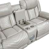 Open center console with stainless steel cup holders, hidden storage, and wireless speakers on gray power loveseat