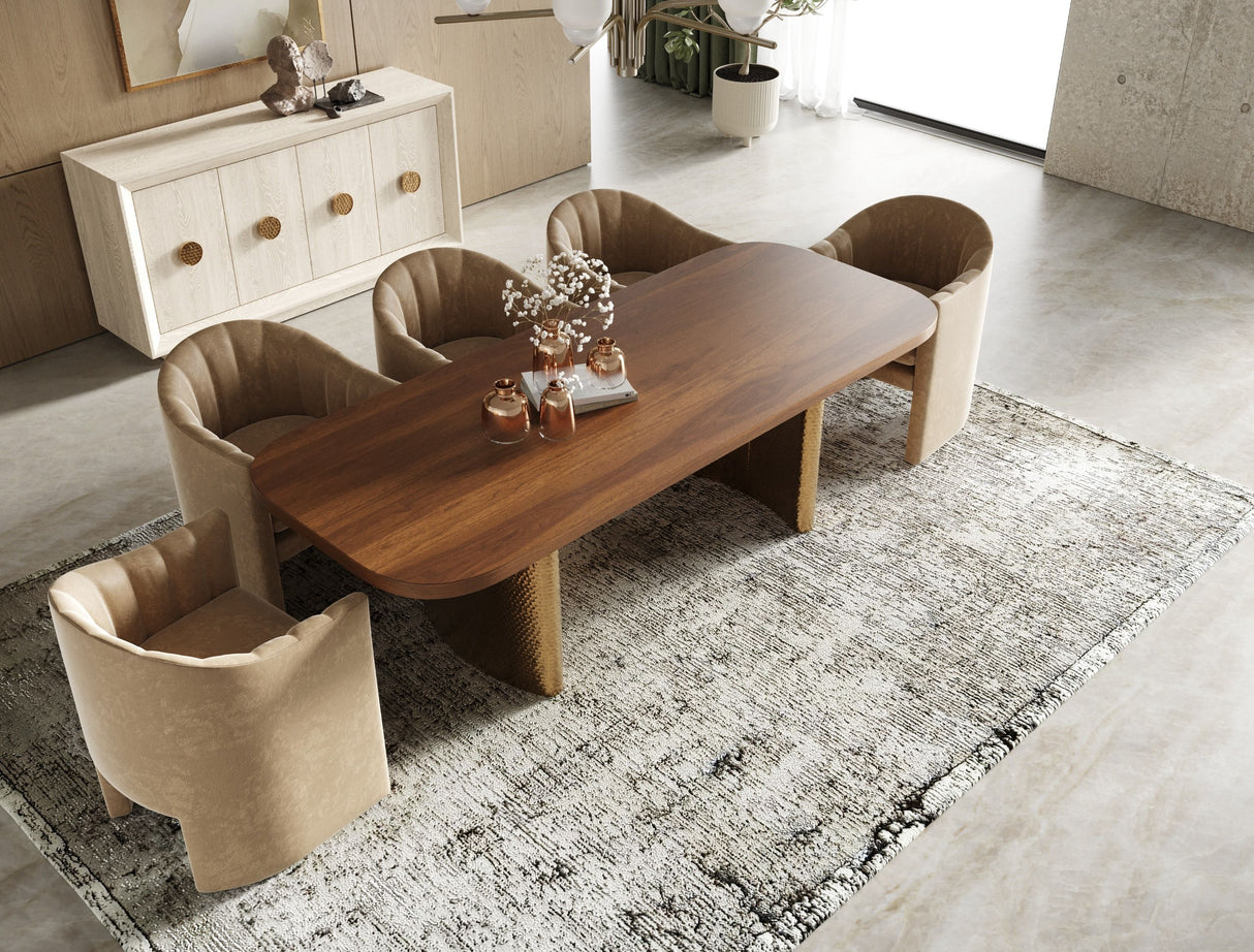 Dining room setup with a wooden table and beige chairs on a patterned rug.